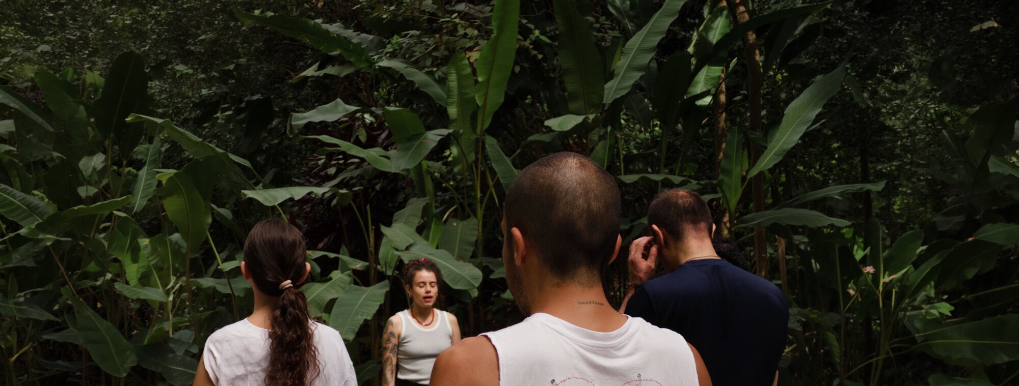 Erika guiando una práctica grupal de respiración en el sendero del bosque
